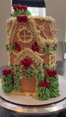 Decorative gingerbread house with icing patterns on a table.