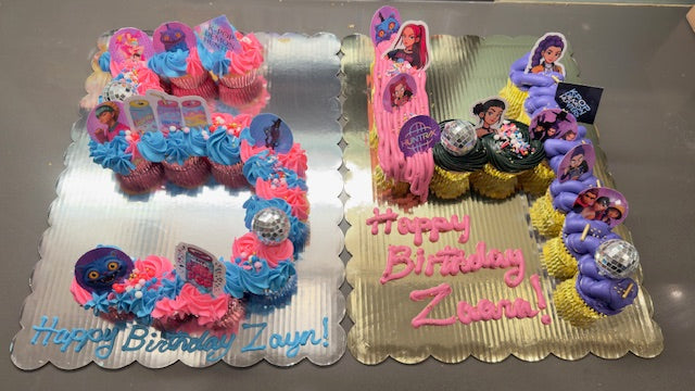 Colorful birthday cake with decorative elements on a reflective surface